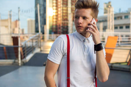 Young man looking back and talking on yhe phone (city life)の写真素材