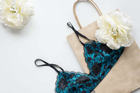 Blue bra on the white table with a paper bagの写真素材