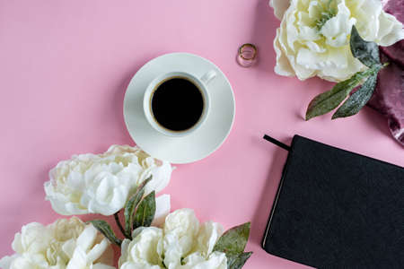Peony flowers on pink background with note and cup of coffee. Planing to do list. Flat lay. Woman workplace.の写真素材