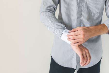 Elegant young fashion man fixing cufflinksの写真素材