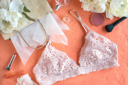 Pink bra and paper bag on the peach color background. Giftの写真素材