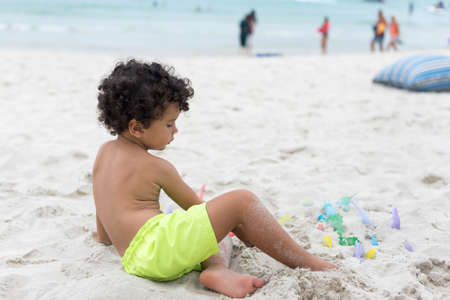 Boy playing with sand on the beach. Holidayの写真素材