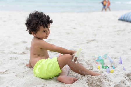 Boy playing with sand on the beach. Holidayの写真素材