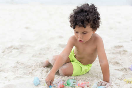 Boy playing with sand on the beach. Holidayの写真素材
