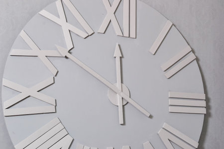 White clock on a white wall. Wall clock on white background, front view. Interior decoration. White...