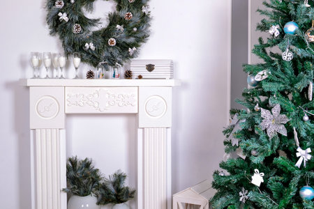 Beautiful living room interior with a fireplace. Christmas celebration. modern style interior of fireplace with christmas tree and presents in white. interior design about copy space or work space for your text in and Christmas party or happy new year concept with Christmas tree on white backgroundの写真素材