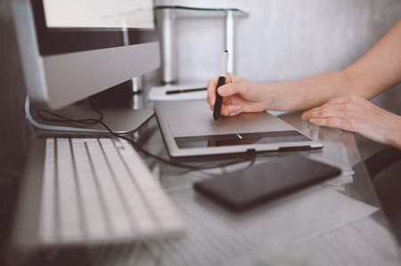 Workplace of photographer or graphic designer. Creative designer hands working on laptop with...