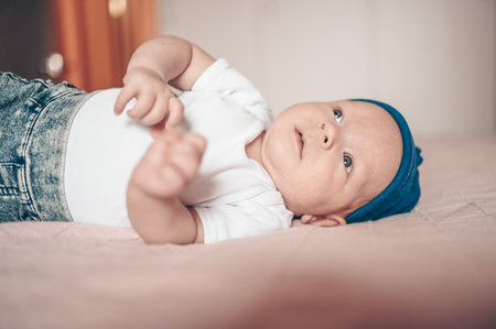 A baby lying on a bed. High quality photo
