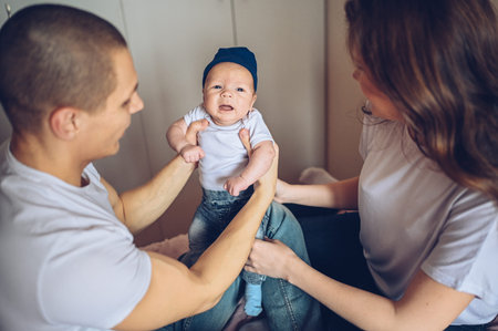 Close up portrait of a happy parents holding their baby. Young happy family, mom and dad playing...