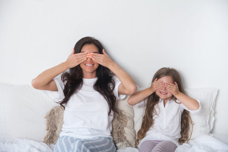 Happy loving family lying relaxing and enjoying in bedroom together. Mother and her cute preschool...