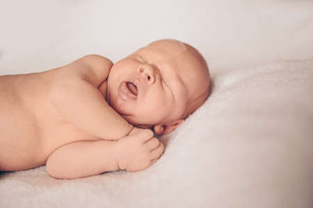 Cute emotional funny newborn little baby boy sleeping in crib. Baby goods packaging template. Healthy child, concept of hospital and happy motherhood. Infant baby. Nursery.の写真素材
