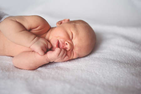 Cute emotional funny newborn little baby boy sleeping in crib. Baby goods packaging template. Healthy child, concept of hospital and happy motherhood. Infant baby. Nursery.の写真素材
