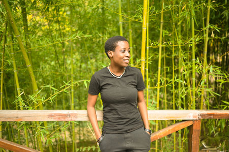Attractive happy smiling young natural beauty short haired African Black woman laughing leans on a...