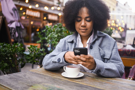 Street style portrait of attractive young happy African American woman with afro hair have video...