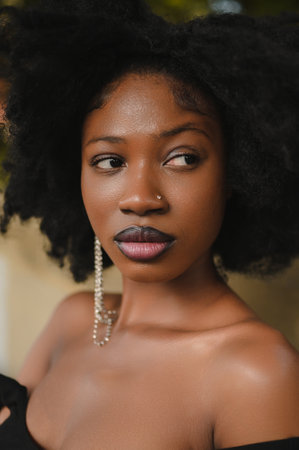Fashion outdoor street style portrait of Beautiful young African American woman posing outside on urban city landscape summer day wearing pink jacket. Attractive black female, diversity conceptの写真素材