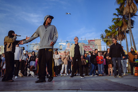 9 March 2024, Los Angeles, USA. Performance by dancers and artists in crowd of tourists on Venice beach, California. Street talent show in public place with a lot of audiences excite and enjoyのeditorial素材