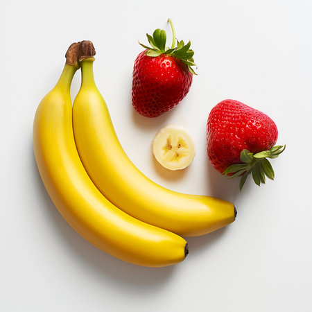 Strawberry & banana on white, top view. Ripe banana with fresh strawberries on white background. Bananas and strawberries arranged on white. Strawberry banana still lifeの素材