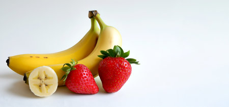 Banana and strawberry isolated on white background, copy space. Strawberry banana isolated. Fresh bananas and strawberries, perfect for smoothie, yogurt, healthy desserts. Organic vegan ingredientの素材