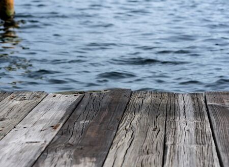 textured background - old wooden dock over blue waterの写真素材