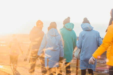 Back view of group of tourists in the sunrise light in Iceland