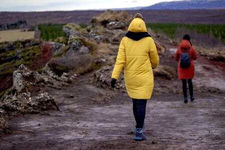 Back view of two women tourists hiking in the mountains in Icelandの写真素材