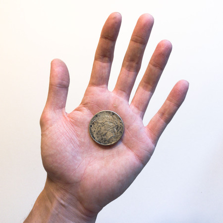 Hand holding a 1923 silver dollarの写真素材