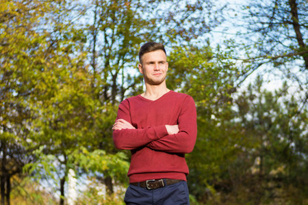 tall guy standing in an autumn parkの写真素材