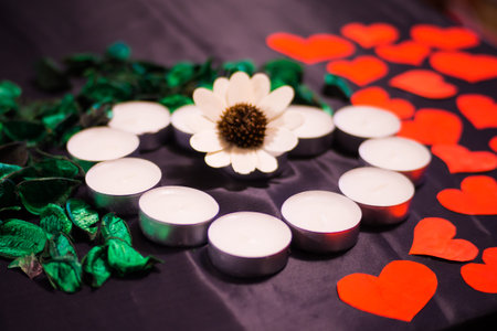 heart made of candles with green petals and postcards