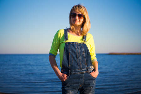 A girl wearing glasses on the beach in the evening at sunsetの写真素材