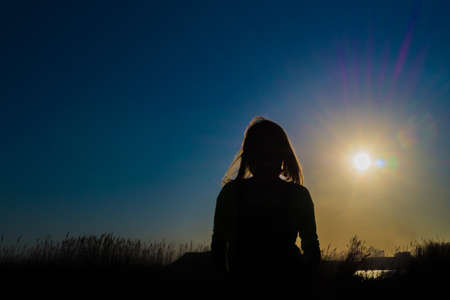 Silhouette of a girl at sunsetの写真素材