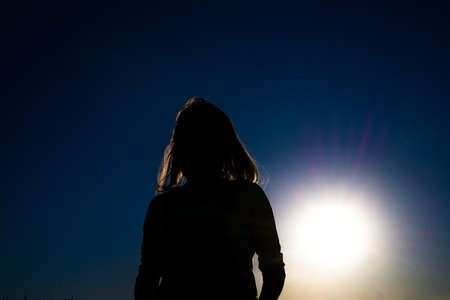 Silhouette of a girl at sunsetの写真素材