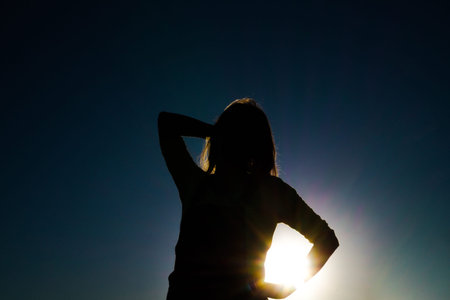 Silhouette of a girl at sunsetの写真素材