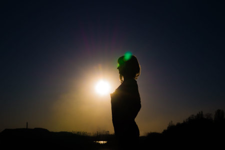 Silhouette of a girl at sunsetの写真素材