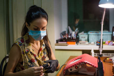 The master of nail extensions and coating with gel varnish makes correction to his client in the beauty salonの写真素材