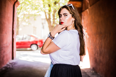 Fashionable and stylish girl in wide black pants, a white T-shirt with sunglasses with a white rim...