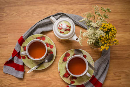 Tea ceremony, filled tea in service with wildflowers on the wood textureの写真素材