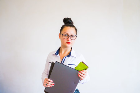 Business lady in glasses for sight with red lipstick on lips, stands on a white background with a...