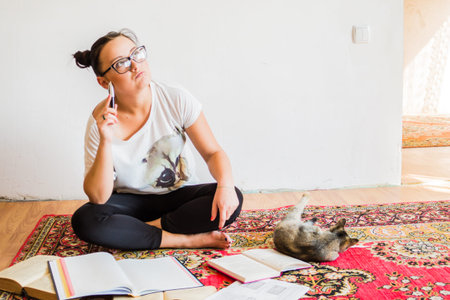 Young girl student with fashion hairstyle horns on her head, doing homework on the floor at home