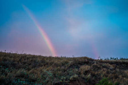Double rainbow in the field, view from the mountainの写真素材