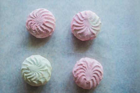 Pink and white marshmallow on white parchment paper