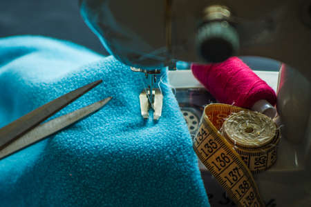 Sewing machine at work, scissors and threadsの写真素材