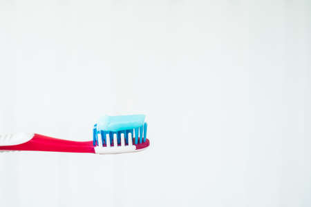 Toothbrush with blue toothpaste on a white background.の写真素材
