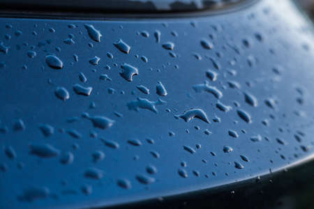 Raindrops on a blue car close-up.の写真素材