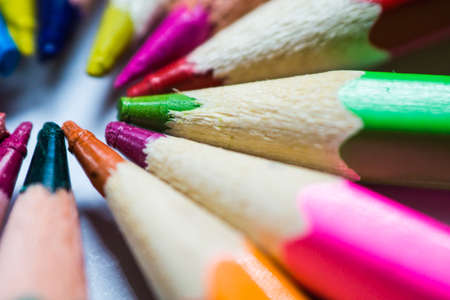 Colored and sharpened pencils lie in a circle next to each other on a white background close-up.の写真素材