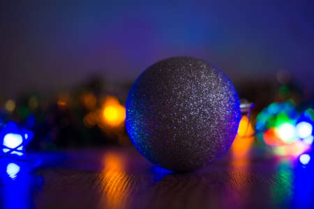 Toy balls on the Christmas tree and cones with multi-colored garlands close-up.の写真素材