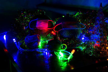 A family of Christmas balls in protective masks from the pandemic. New Year and Christmas in...