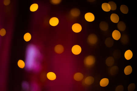 Background of blurred bokeh garlands in dark roomの写真素材