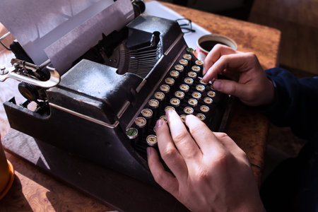 Male writer writing his book on an old antique typewriter. An old antique typewriter.