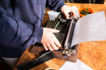 Male writer writing his book on an old antique typewriter. An old antique typewriter.の写真素材