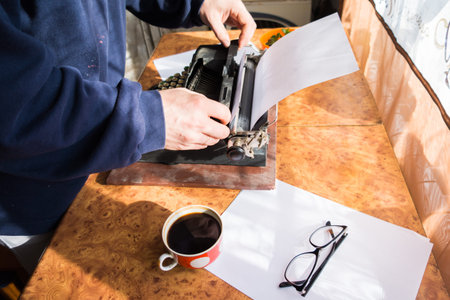Male writer writing his book on an old antique typewriter. An old antique typewriter.